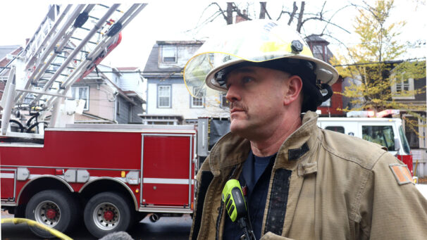 District Chied Adam MacNeil speaks to reporters in front of firetruck