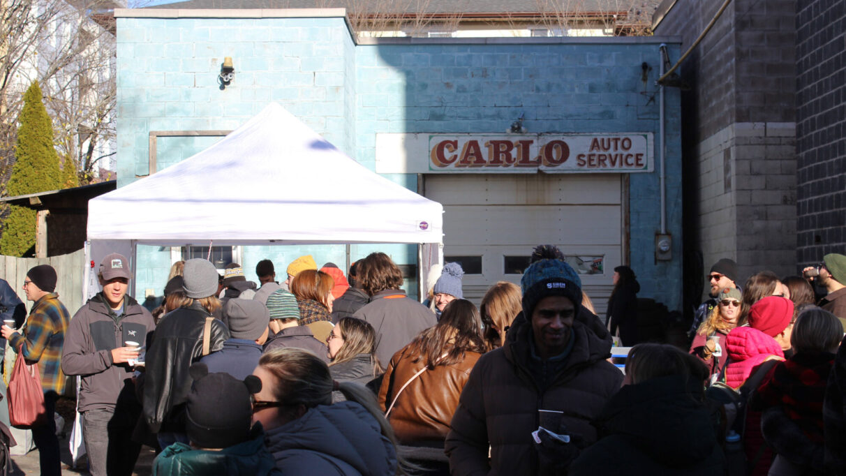 Exterior of Carlo Auto Service with line up in front of a tent for mulled wine.
