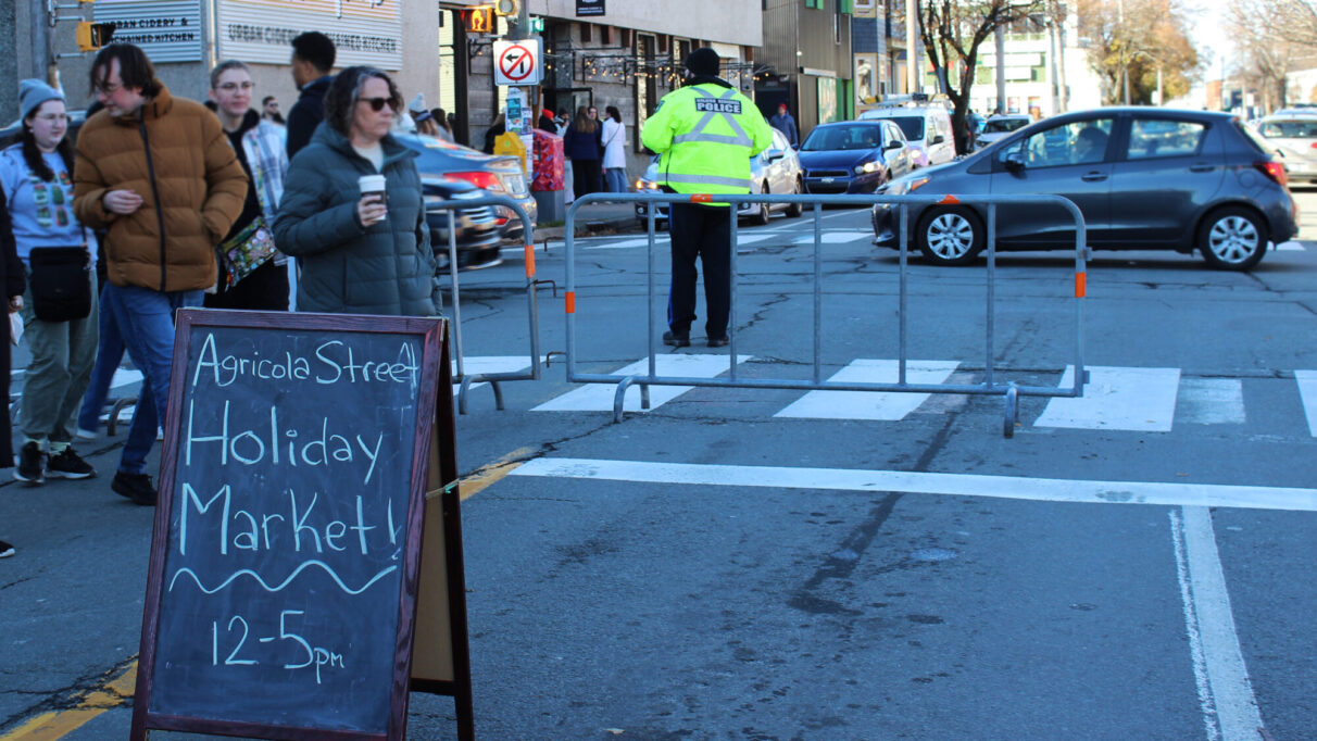 The sign for the Agricola Street Holiday Market in front of the road closure on North Street.