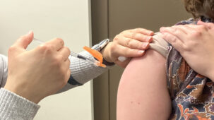 A needle is prepared to be inserted into someone's arm.