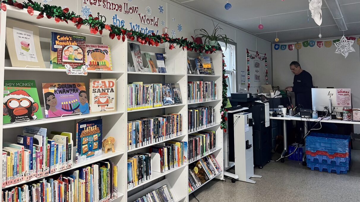 Book shelves line the walls of a trailer library.