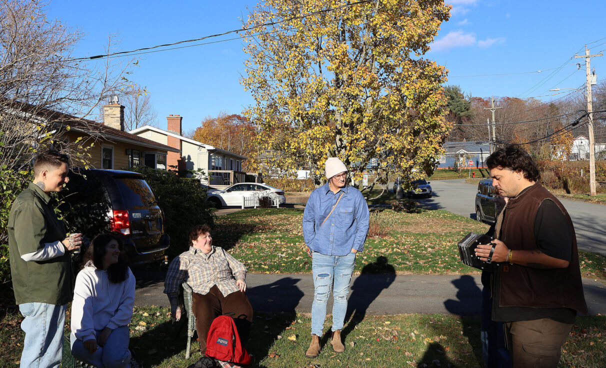 On a bright Sunday, Lydia and the Holy Crow band catch up outside their practice space before jams.