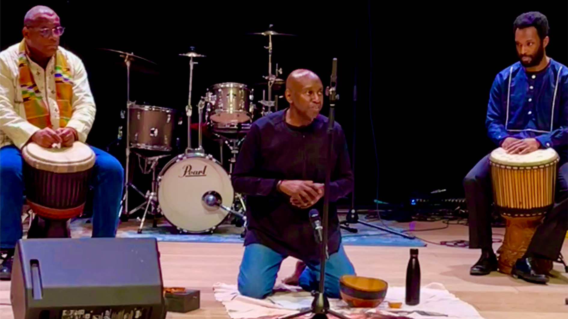Wayn Hamilton performs a libation with two people looking on at Paul O’Regan Hall in Halifax, Nova Scotia