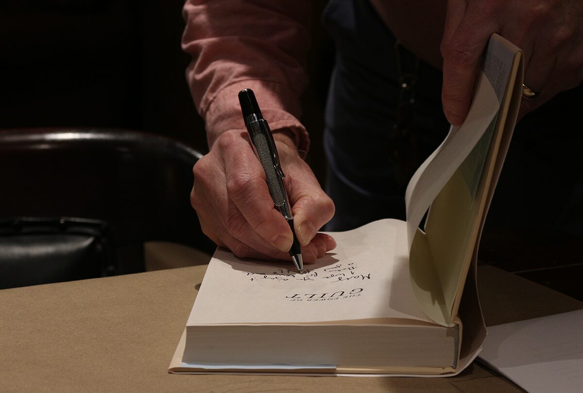 Chris Moore autographs a copy of his new book The Power of Guilt.