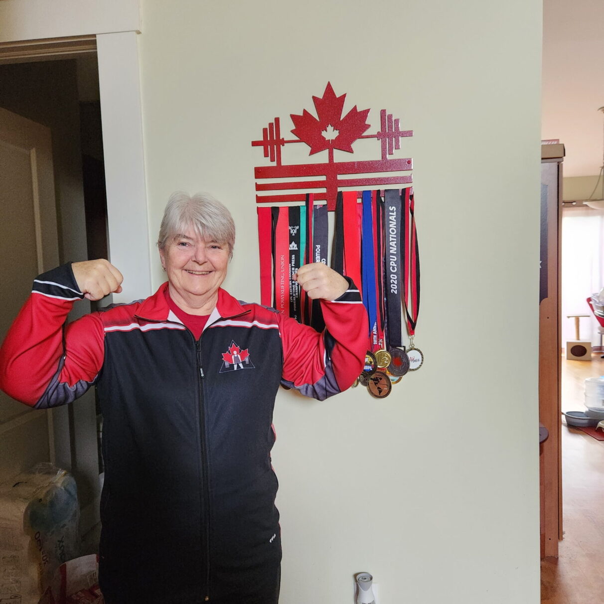 Sue Bonneau poses with her medals in her home in Dartmouth Nova Scotia in 2024.