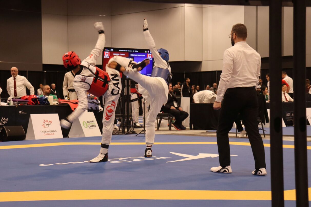 Athletes in a kyorugi match sparring and throwing high kicks at the Taekwondo Canada National Championships.