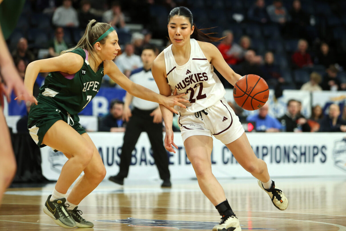 A female Saint Mary's basketball player drives past a UPEI player in last year's AUS championship game.