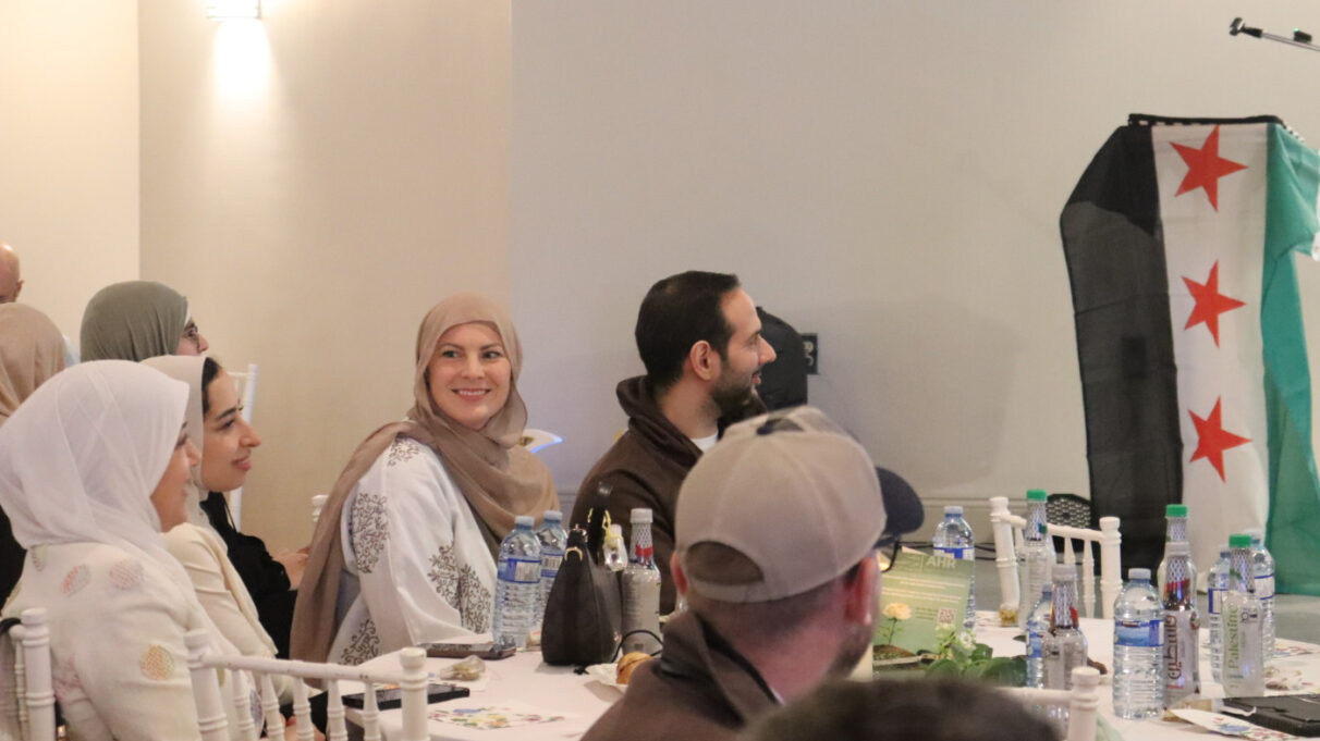 Holly Groshok sits with her husband as she listens to activist and public speaker, Mohamed El-Attar, known as “That Muslim Guy,”, during his speech. (Al-Maysaa Shaheen)