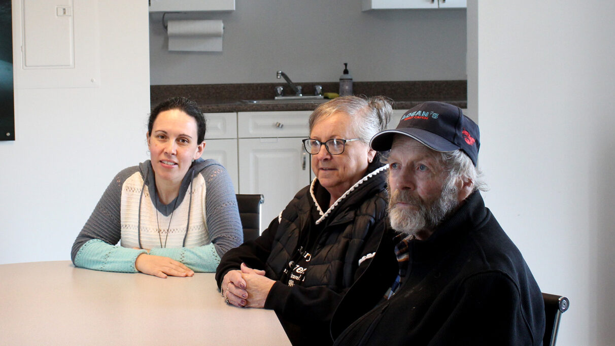 Amy Simon, Helen and Hughie MacDonald sitting at a table in a conference room.