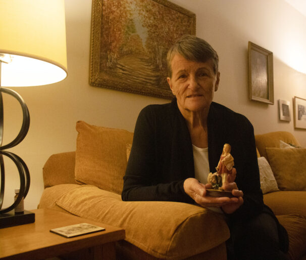 Judy Robichaud holds a small toy in her living room at Clayton Park on November 3, 2025 in Halifax Nova Scotia. The toy of a little girl holding a pillow with a bag pack brings back memories of her late granddaughter, Tahlia, arriving for sleepovers clutching her pillow with her backpack containing her sleepwear and books. This simple object is a reminder of those cherished nights and the joyful presence of her daughter.