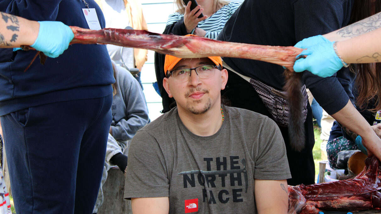 Blair “Joef” Bernard watches workshop participants skin a mink at the L’nui’sultinej conference in Eskasoni, May 2026.