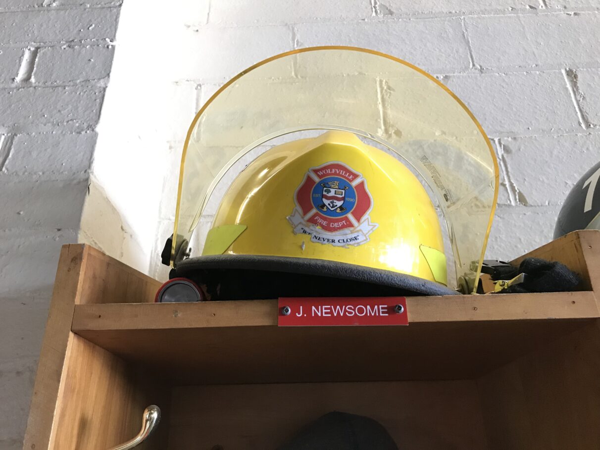 A yellow firefighting helmet on top of a shelf.